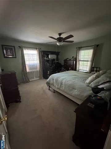 a bedroom with a bed and large windows