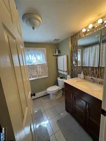 a bathroom with a sink a toilet a mirror and vanity