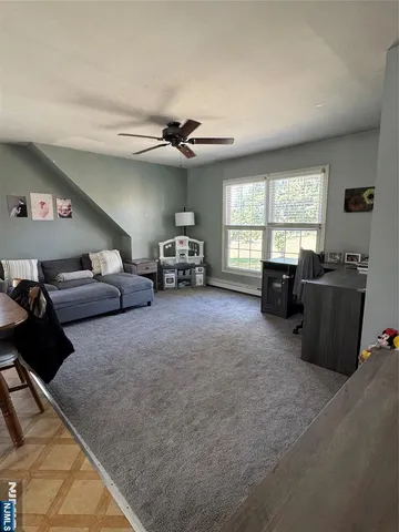 a living room with furniture a flat screen tv and a large window