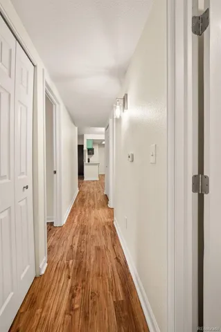 a view of a hallway with wooden floor and staircase