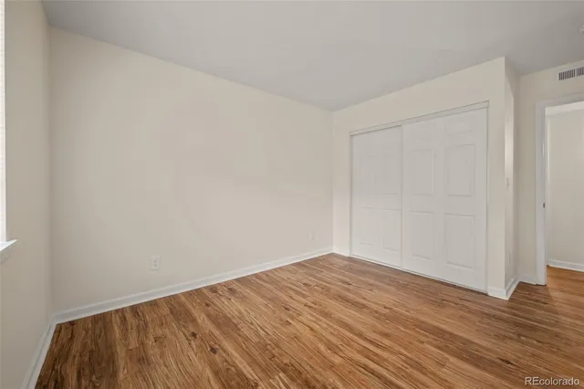 a view of an empty room with wooden floor