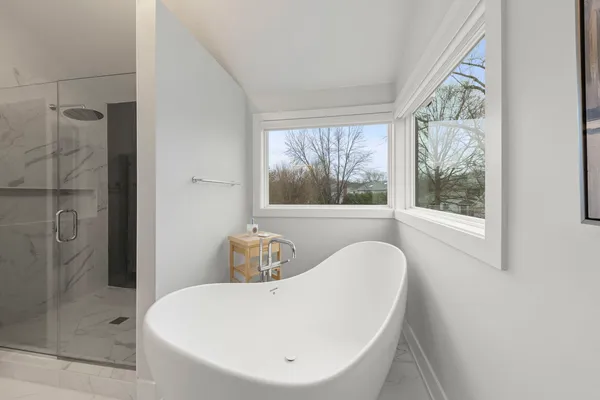 a bathroom with a toilet a sink a mirror and shower