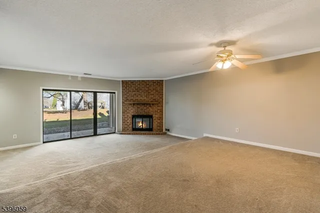 a view of an empty room with window and fireplace