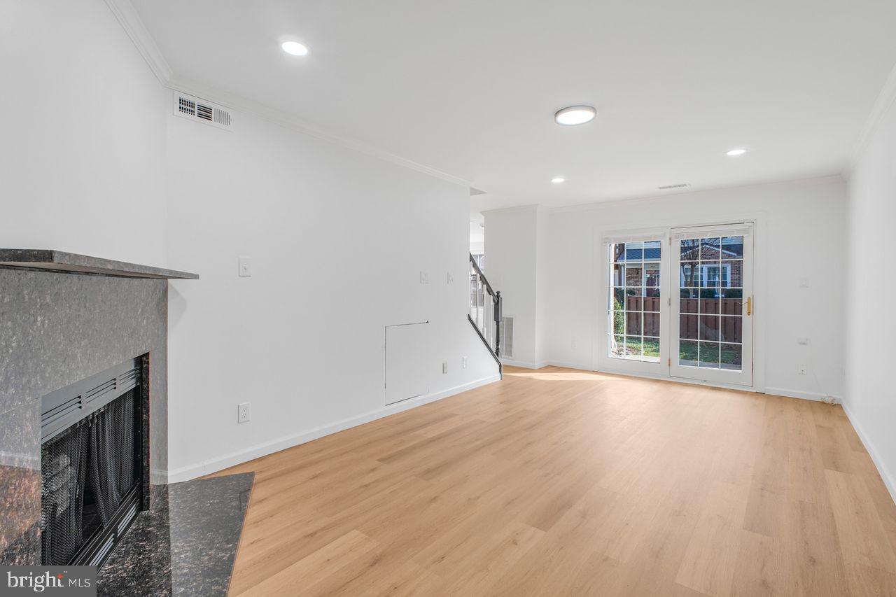 4047 Chetham Way Woodbridge, VA 22192 - Photo 20 of 55 a view of an empty room with wooden floor and a fireplace