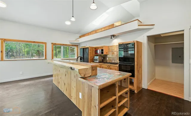 a kitchen with stainless steel appliances granite countertop a stove a sink and a refrigerator