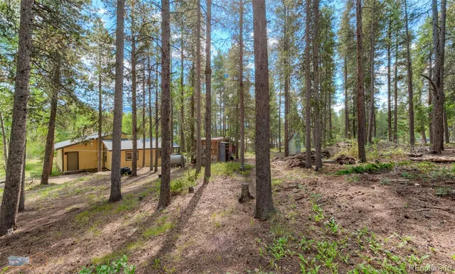 a view of a small house with backyard