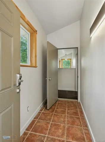 a view of an empty room with wooden floor fireplace and a window