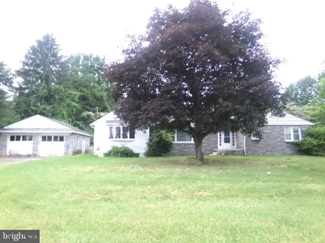 a front view of a house with a yard and trees