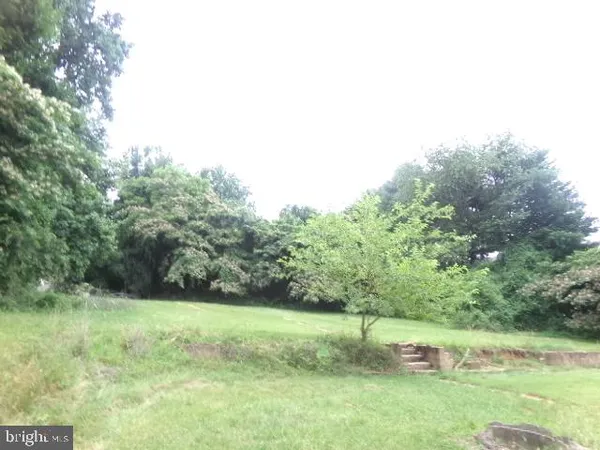 a view of a green field with wooden fence