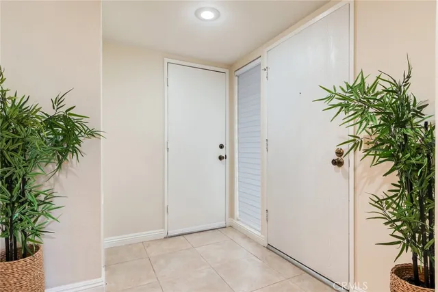 a view of an entryway with potted plants and palm trees