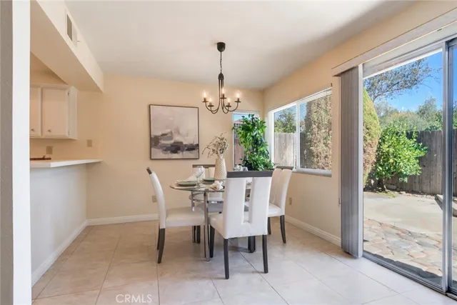 a dining room with furniture a chandelier and window