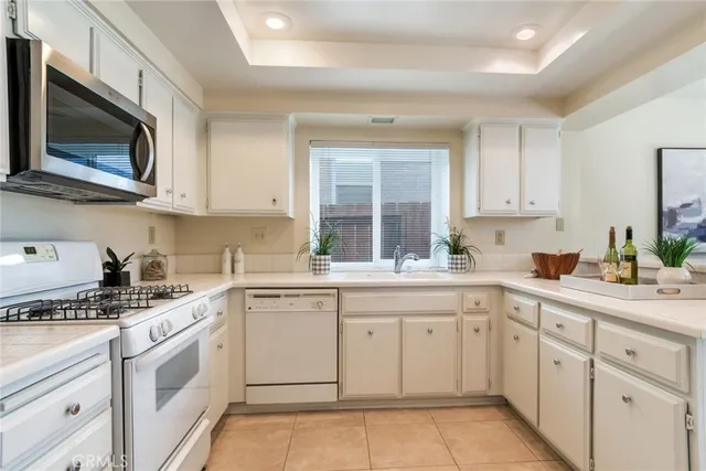 a kitchen with cabinets appliances a sink and a window