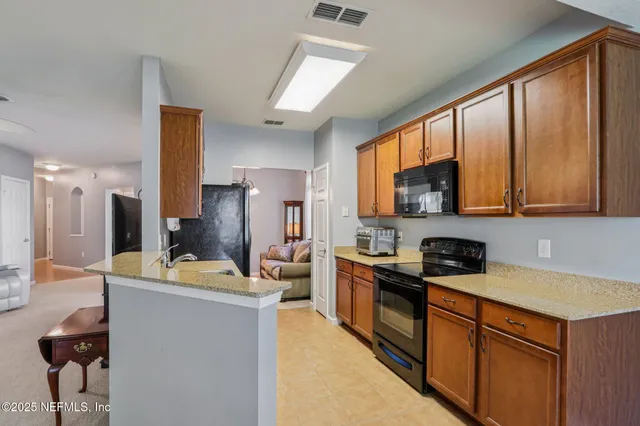 a kitchen filled counter top space a sink stainless steel appliances and cabinets