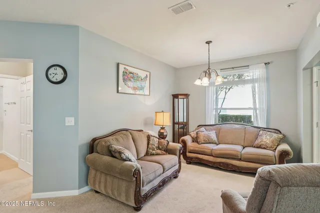 a living room with furniture and a chandelier
