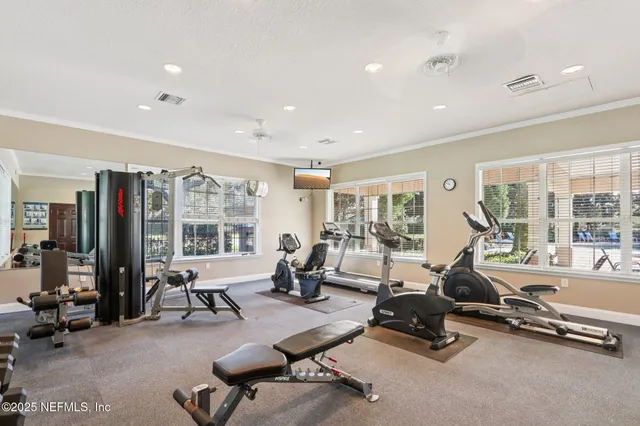 a view of a lake with lawn chairs and large trees