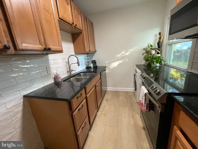 a kitchen with stainless steel appliances granite countertop a sink stove and cabinets