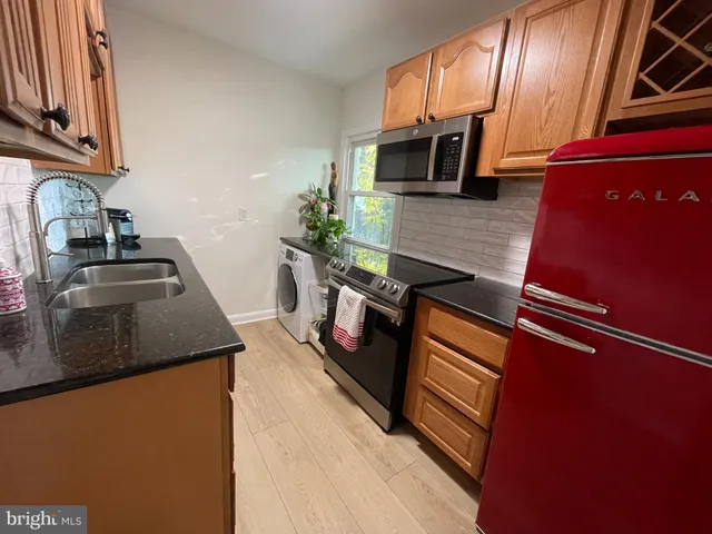 a kitchen with stainless steel appliances granite countertop a sink stove and microwave