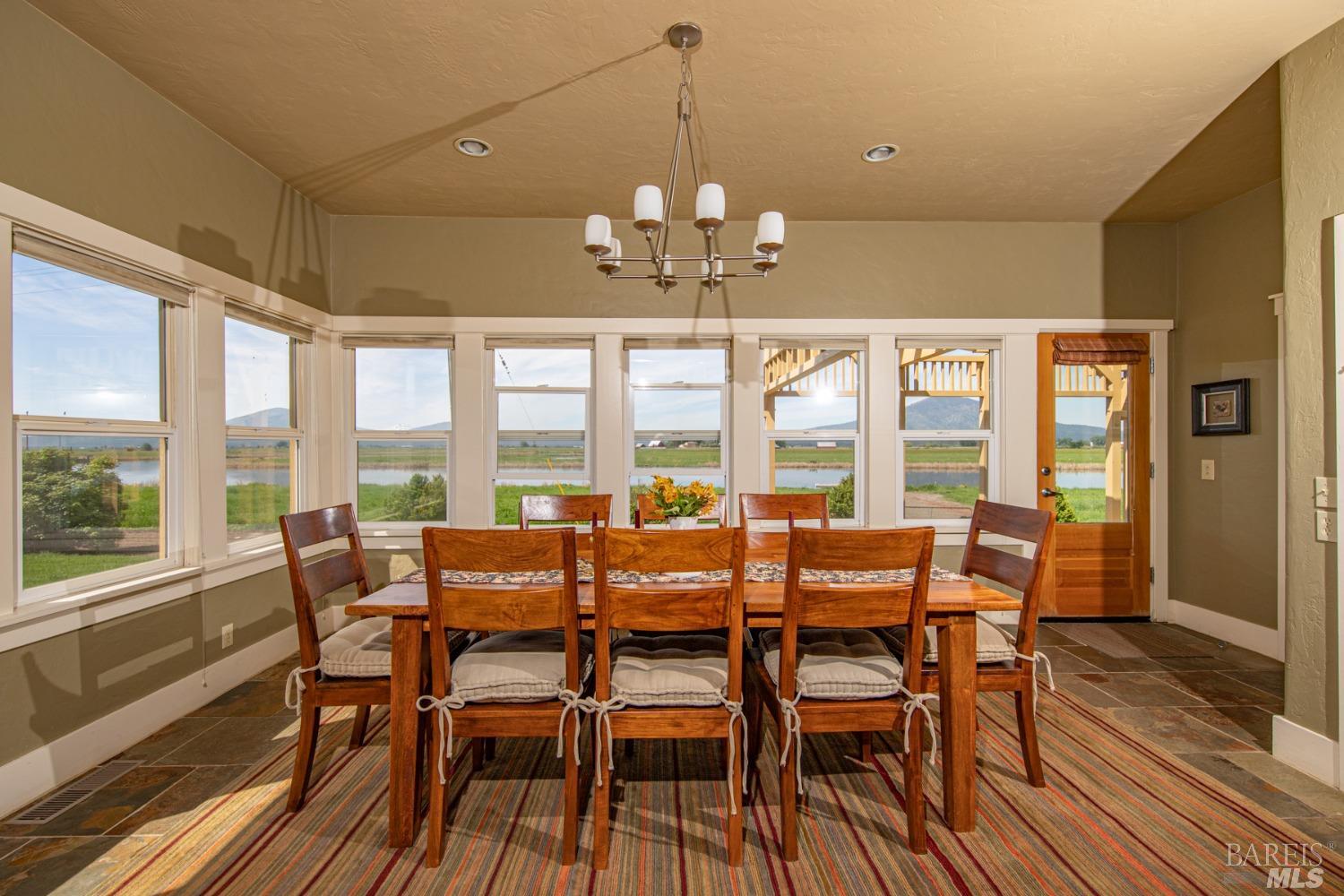 42369 Horr Road Fall River Mills, CA 96028 - Photo 13 of 43 a view of a dining room with furniture large windows and wooden floor