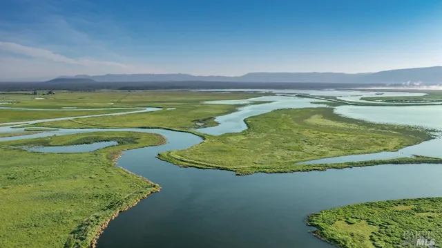 a view of a house with a small yard and wooden fence