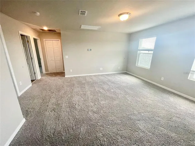 an empty room with windows and closet
