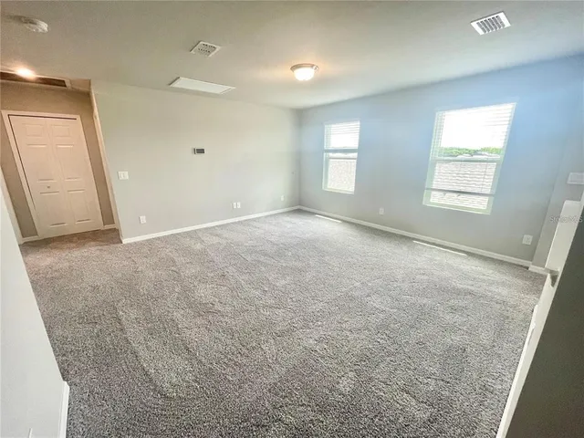an empty room with windows and closet