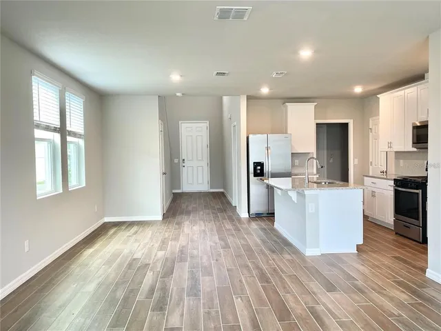 a view of kitchen with wooden floor and electronic appliances