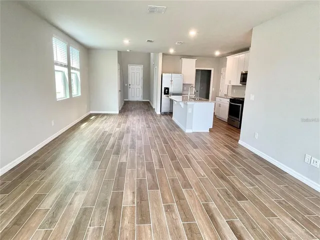 a view of a kitchen with wooden floor and windows