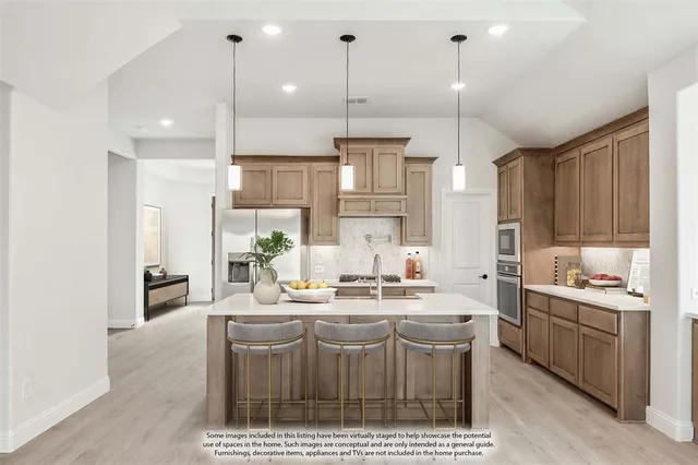 a kitchen with kitchen island granite countertop a sink a counter space appliances and cabinets