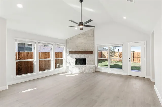a view of an empty room with a fireplace and a window