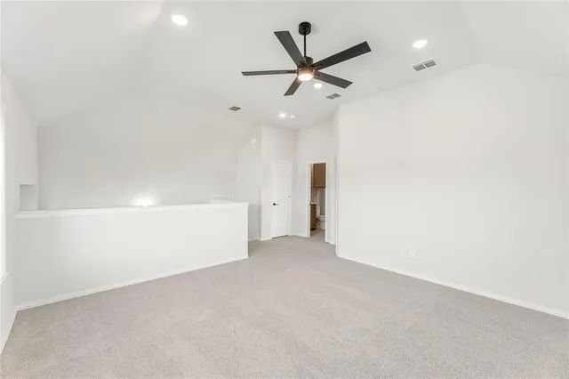 an empty room with ceiling fan and window