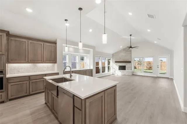 a kitchen with a sink a center island a counter space and a view of living room