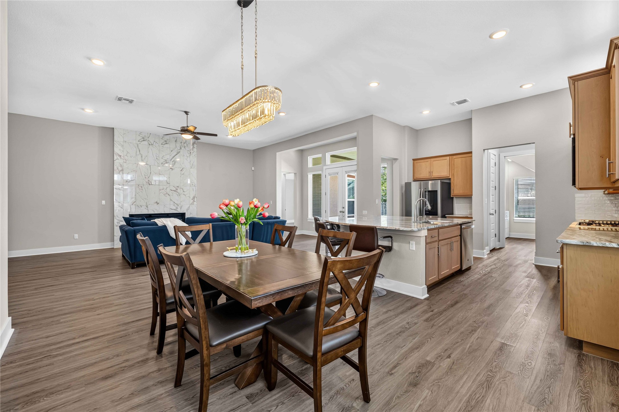605 A Mallow Road Leander, TX 78641 - Photo 10 of 29 An open-concept living area features a dining space and a kitchen with an island, all bathed in natural light.