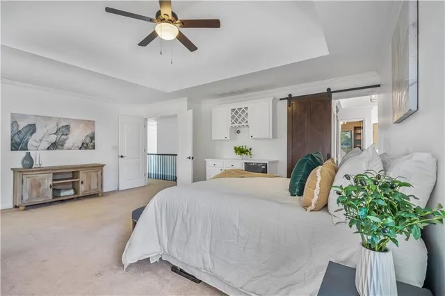 a bedroom with a bed potted plant on the dresser and a chandelier