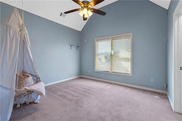 a view of an empty room with window chandelier fan