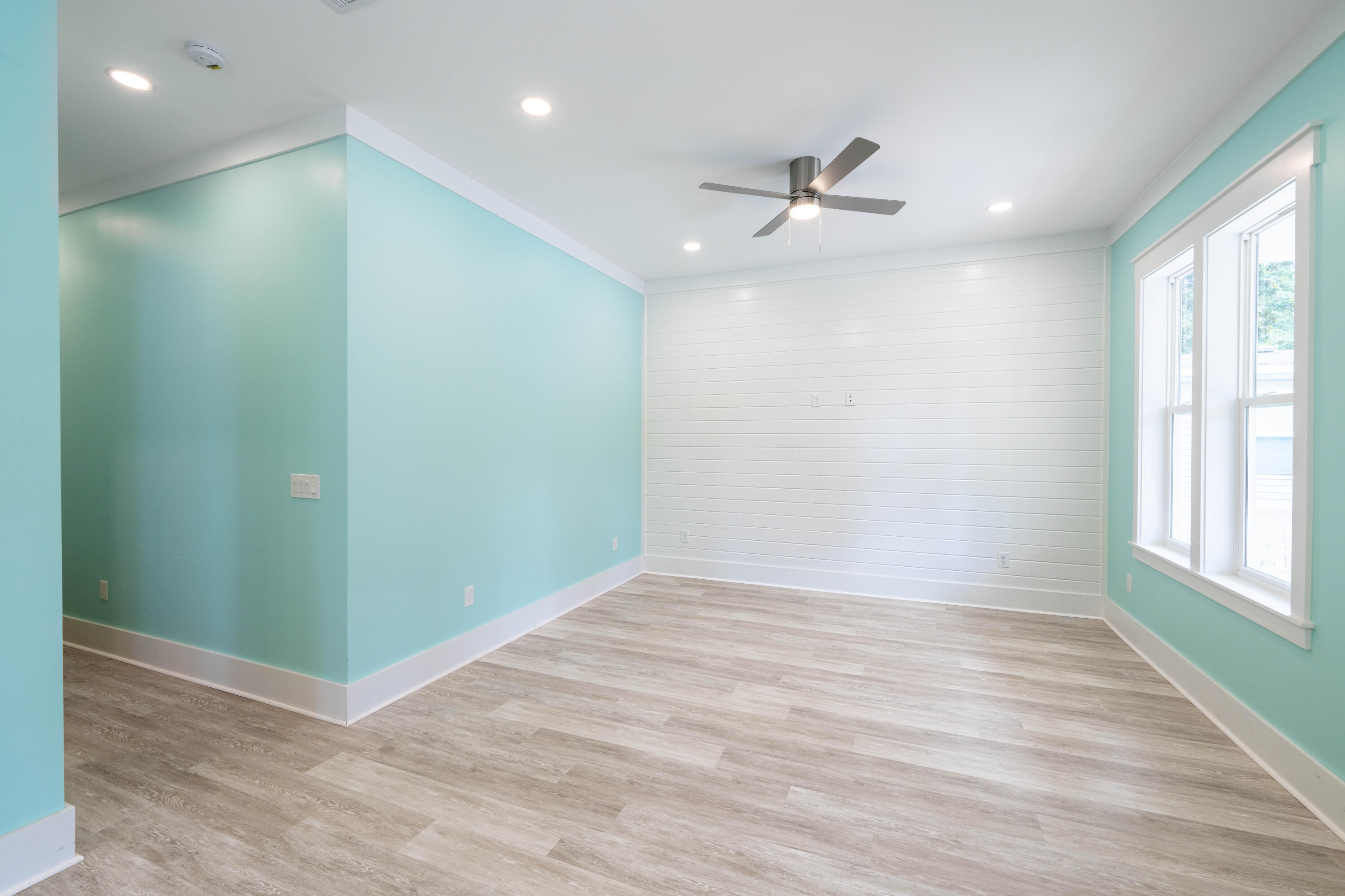 101 4th Street Santa Rosa Beach, FL 32459 - Photo 6 of 16 an empty room with wooden floor fan and windows