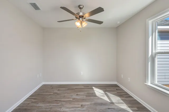 wooden floor in an empty room with a window