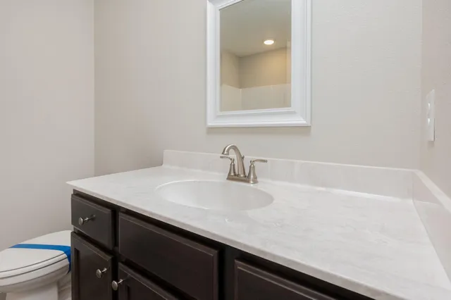 a bathroom with a sink a toilet and a mirror