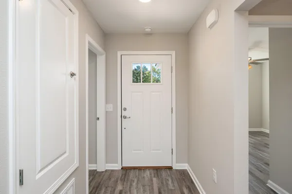 a view of a hallway with wooden floor and closet area