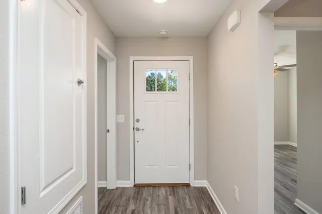 a view of a hallway with wooden floor and closet area