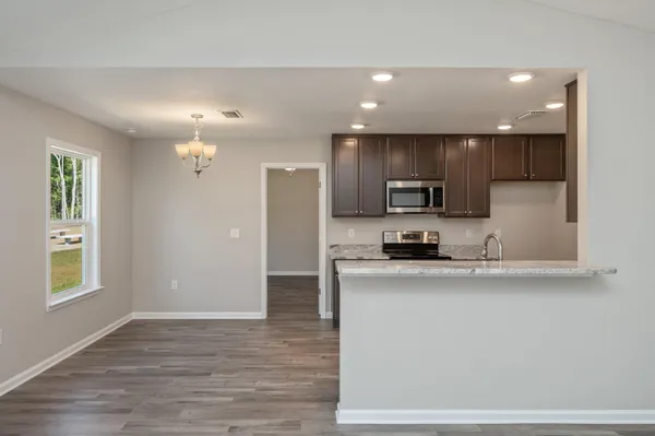 a kitchen with stainless steel appliances granite countertop a refrigerator a sink a stove and oven