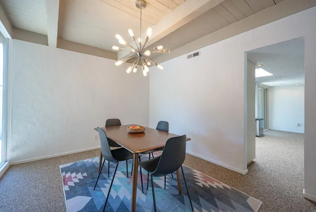 a kitchen with granite countertop a refrigerator and white cabinets