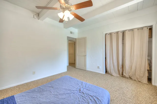 a bed sitting in a bedroom next to a window