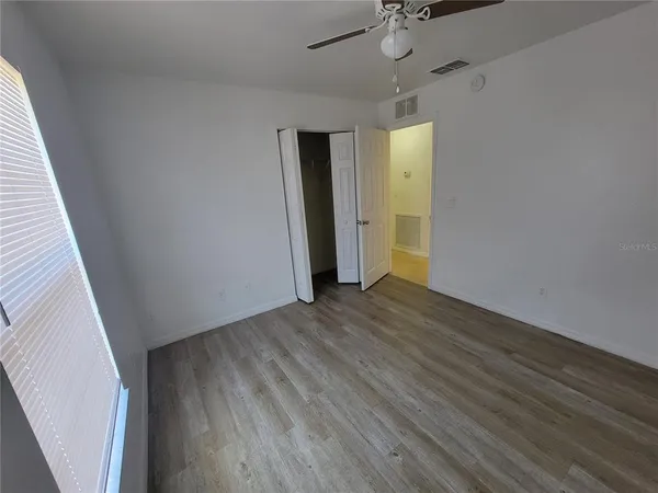 a view of an empty room with wooden floor
