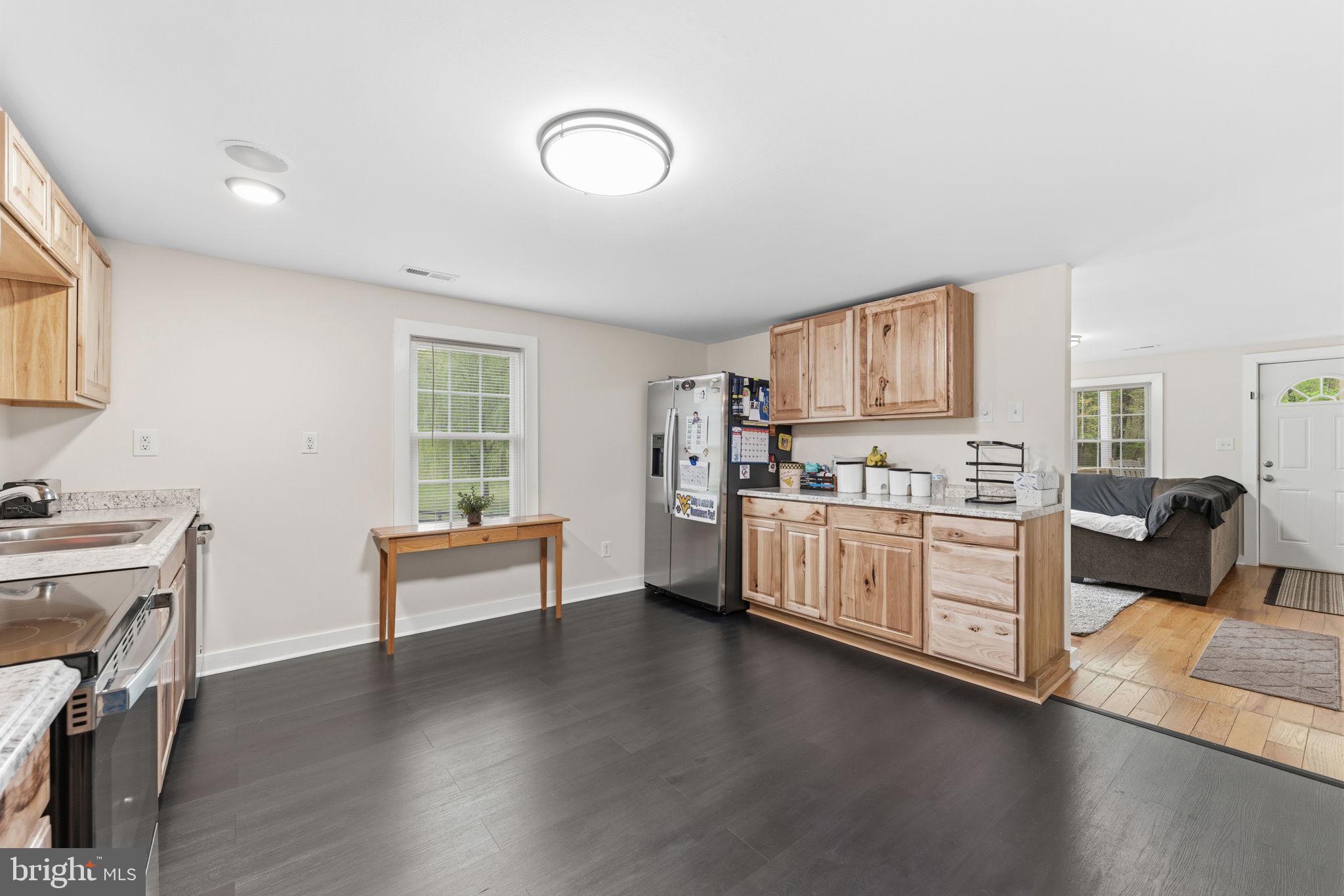 2459 Thoroughfare Road Culpeper, VA 22701 - Photo 43 of 59 a kitchen with stainless steel appliances a stove top oven a sink a dining table and chairs with wooden floor
