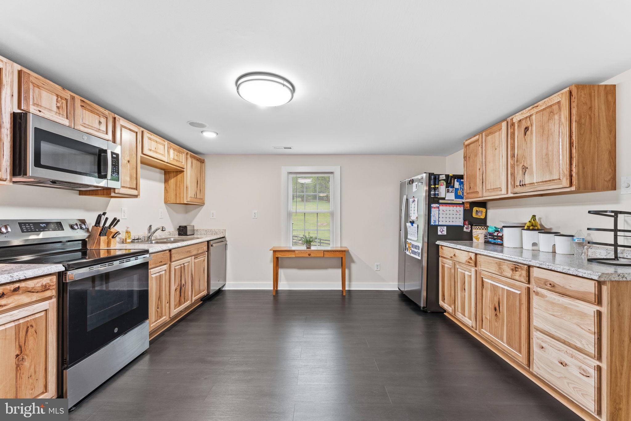 2459 Thoroughfare Road Culpeper, VA 22701 - Photo 44 of 59 a kitchen with stainless steel appliances granite countertop a stove top oven a sink dishwasher and a microwave oven with white cabinets