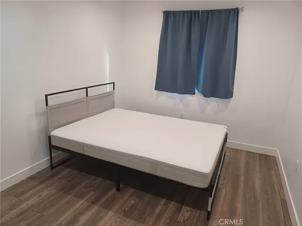 a bed sitting in a bedroom next to a wooden cabinet