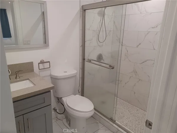 a bathroom with a toilet sink vanity and shower
