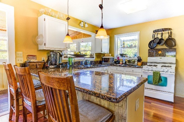 4449 Mahimahi Road Hanalei, HI 96714 - Photo 7 of 20 a kitchen with a stove a sink and a wooden floor