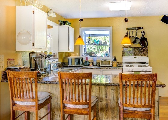 4449 Mahimahi Road Hanalei, HI 96714 - Photo 8 of 20 a kitchen with a stove a sink and a wooden cabinets
