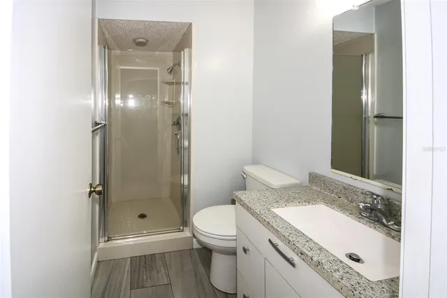 a bathroom with a granite countertop sink toilet and shower